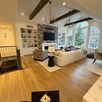 Family room with built-in shelving and a beamed ceiling after a post-renovation clean