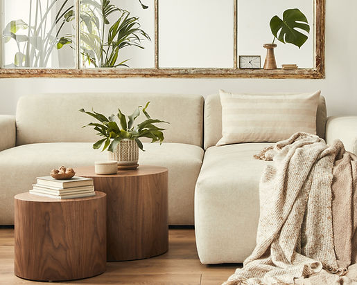 Bright short-term rental living room with a cream sectional, wood side tables and a knit throw
