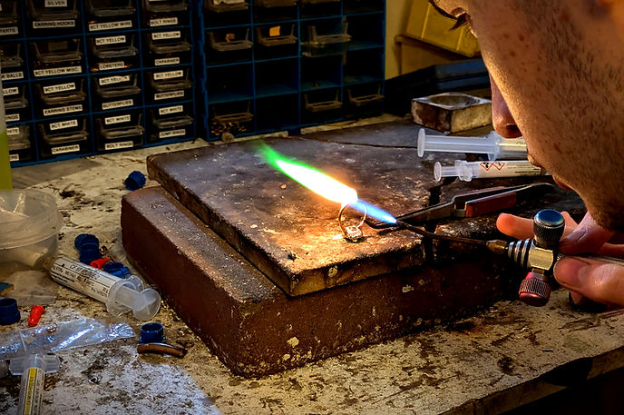 Gold ring on workshop table being soldered