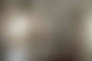 Unearthed Interiors Morris Kitchen | Full Service Interior Design Firm | Kitchen Gut Renovation | A view of a stove with a white plaster hood ventUnearthed Interiors Morris Kitchen | Full Service Interior Design Firm | Kitchen Gut Renovation | A view of a stove with a white plaster hood vent and white pendat lights over the island a a black pendant over the sink