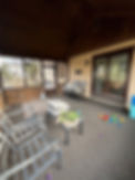 Eye-level view of a rundown screen porch with peeling paint and torn screens