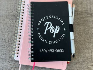 Two spiral notebooks, black and pink, with "Professional Organizing Plus" used for professional organizing consultations in Phoenix, AZ