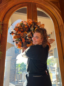 A professional organizer in Paradise Valley, AZ hanging a seasonal garland on a window