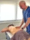 uan Manuel Lázaro, fisioterapeuta, realizando un tratamiento de terapia manual sobre la espalda de un paciente tumbado en camilla, en una clínica de fisioterapia