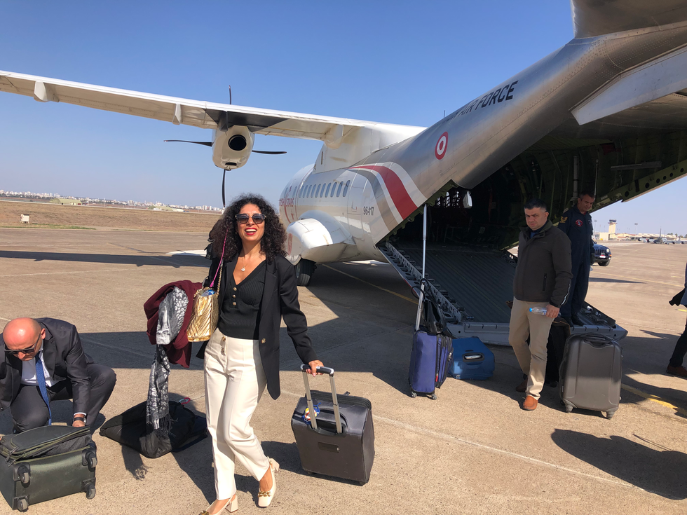 In front of c130 aircraft with luggage