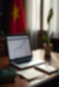 A professional desk with a Vietnamese flag, a laptop showing government documents, and a passport with a visa stamp.