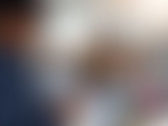 Foreign workers in South Korean manufacturing facility with E-9 visa documents and HRDKorea EPS website on smartphone.