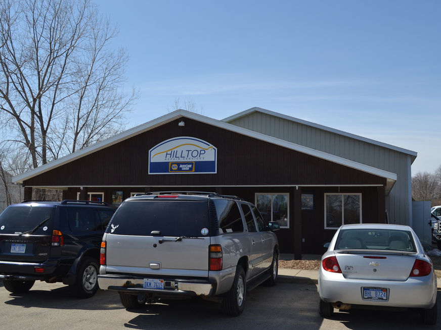 Hilltop Truck & Auto Body building with parked cars