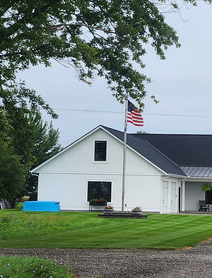 White building with American flag on green lawn