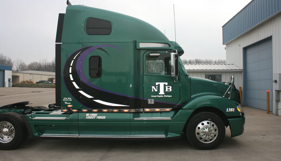Green NTB semi-truck cab with curved road graphic and logo