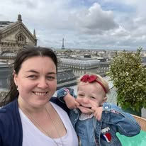 Bea showing little respect for the Paris skyline at a rooftop cafe