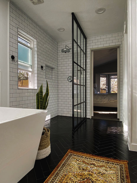 Open bathroom in Golden, Colorado with black tile flooring, tub, and glass shower wall.