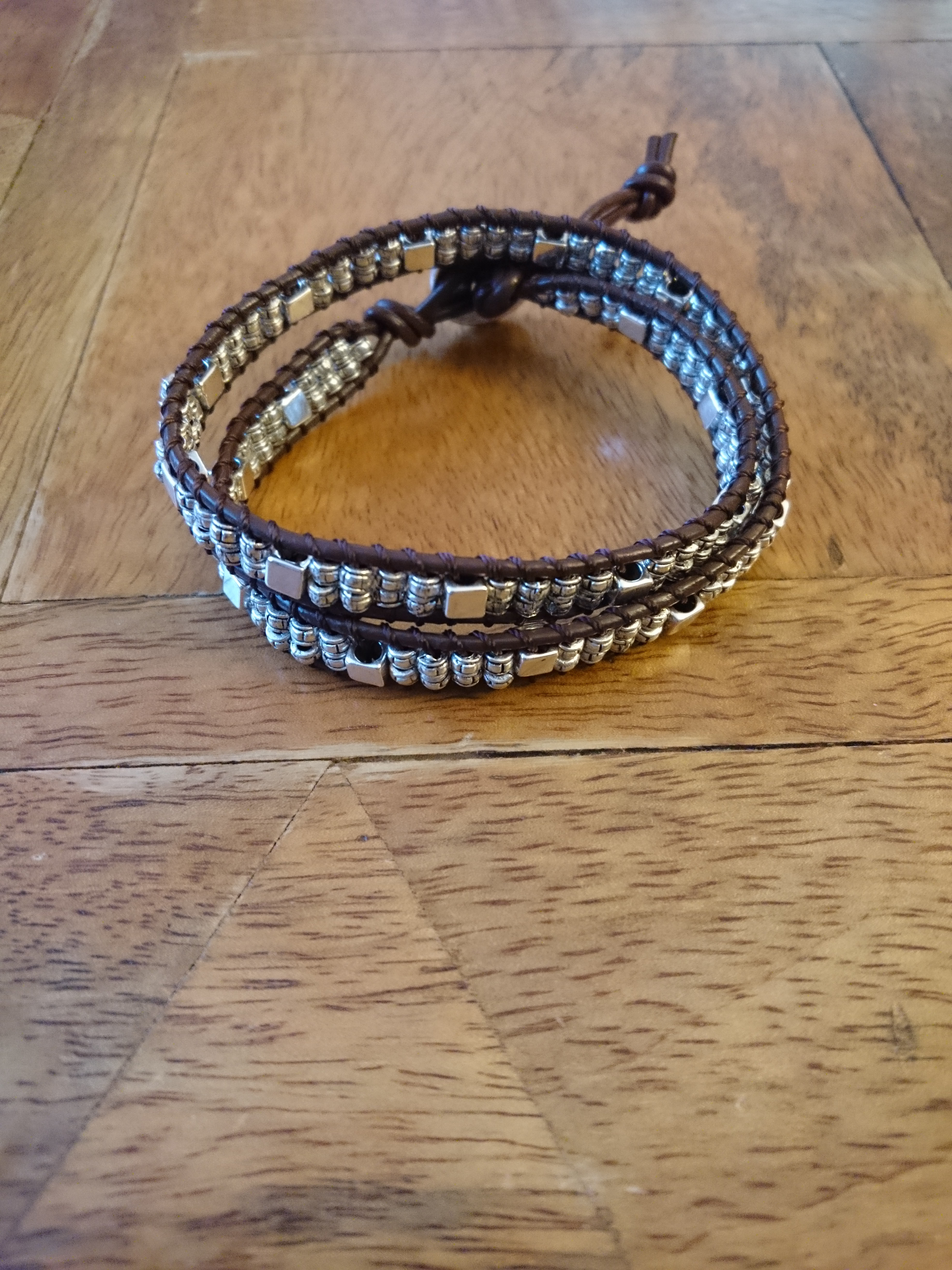 Pulsera de cuero marrón y cuentas plateada.