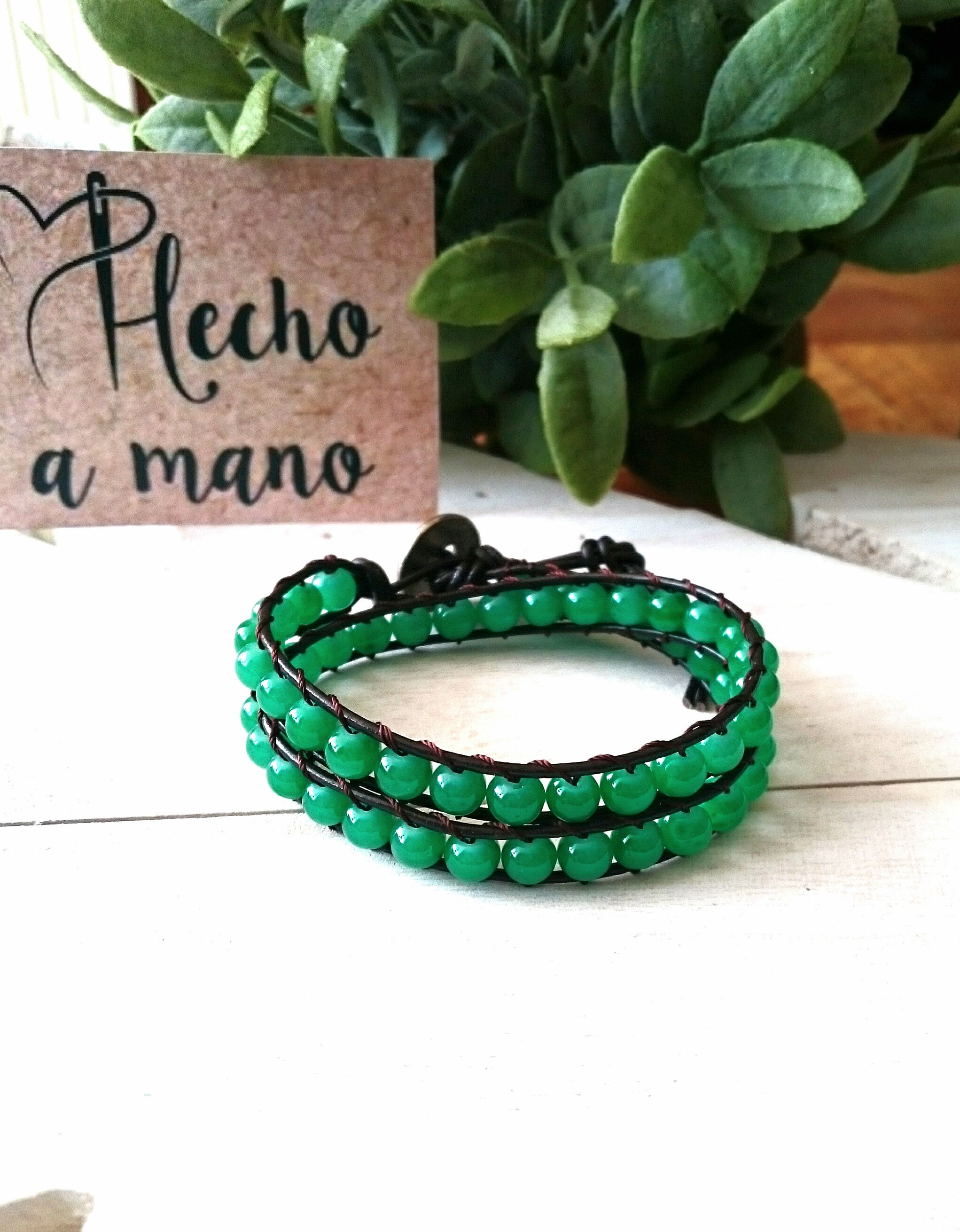 Pulsera de cuero marrón y de cristal verde.