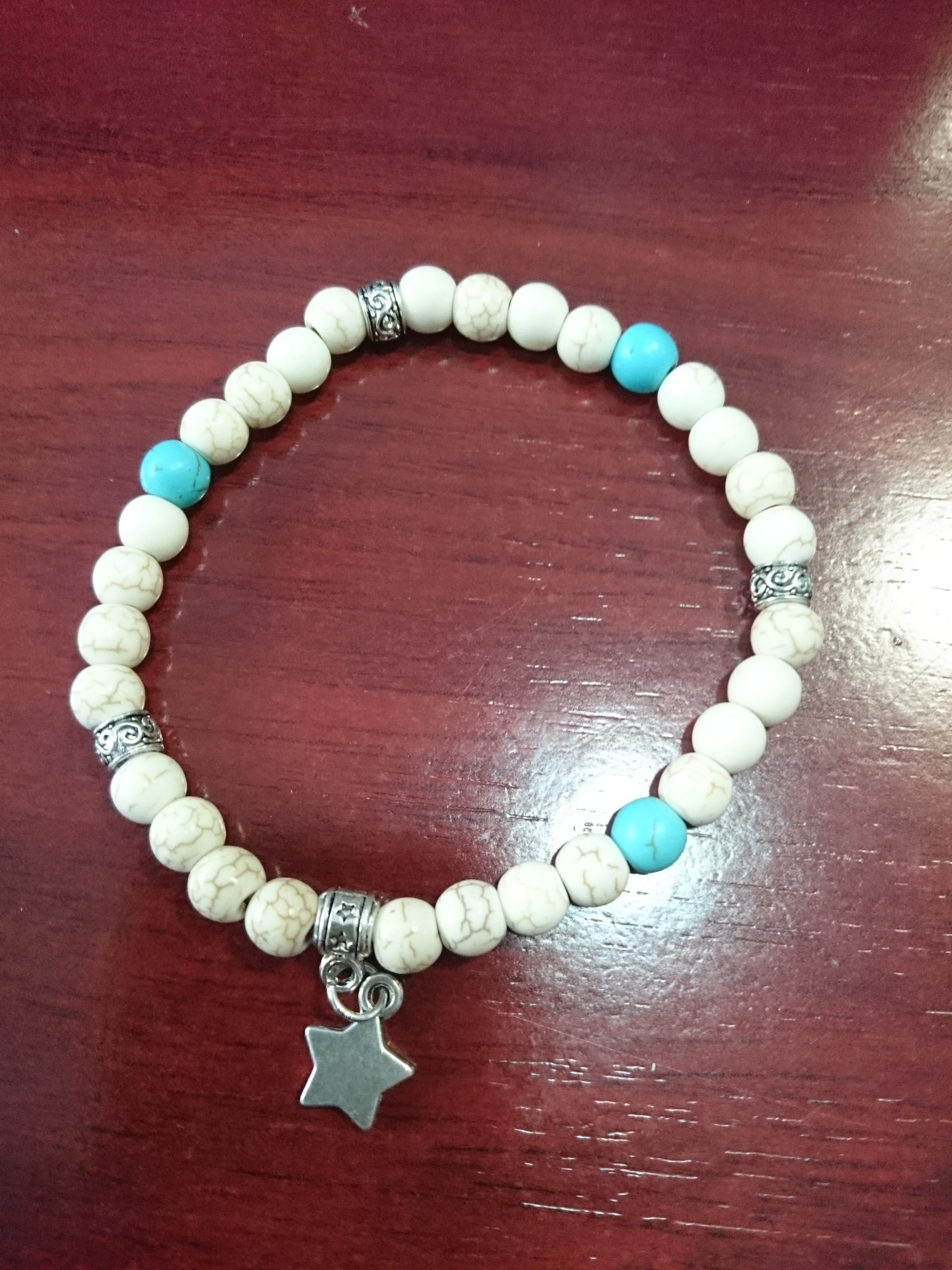 Pulsera de piedra blanca y turquesa con abalorios de metal y estrella.