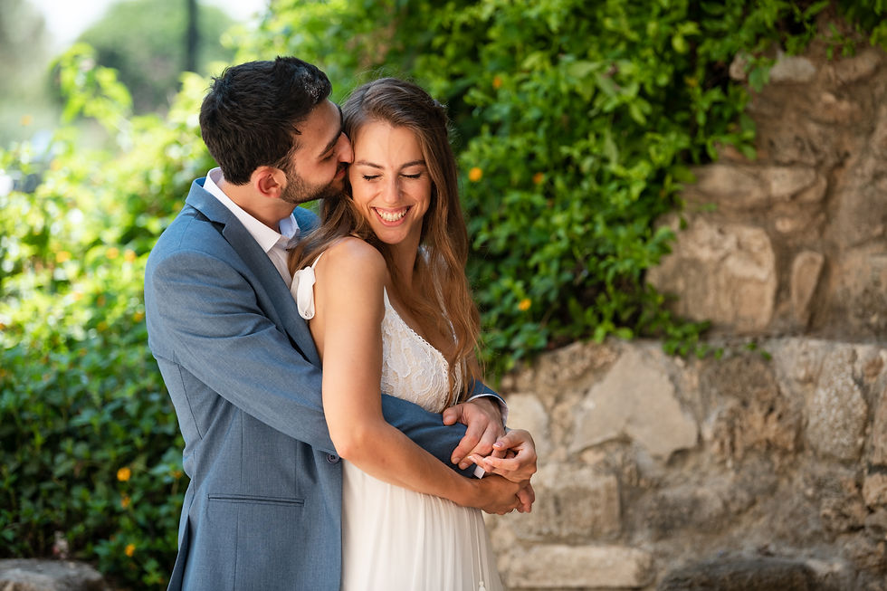 חתן מחבק כלה מאחור ומנשק אותה