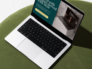 Laptop open on green sofa with CVilla Design website