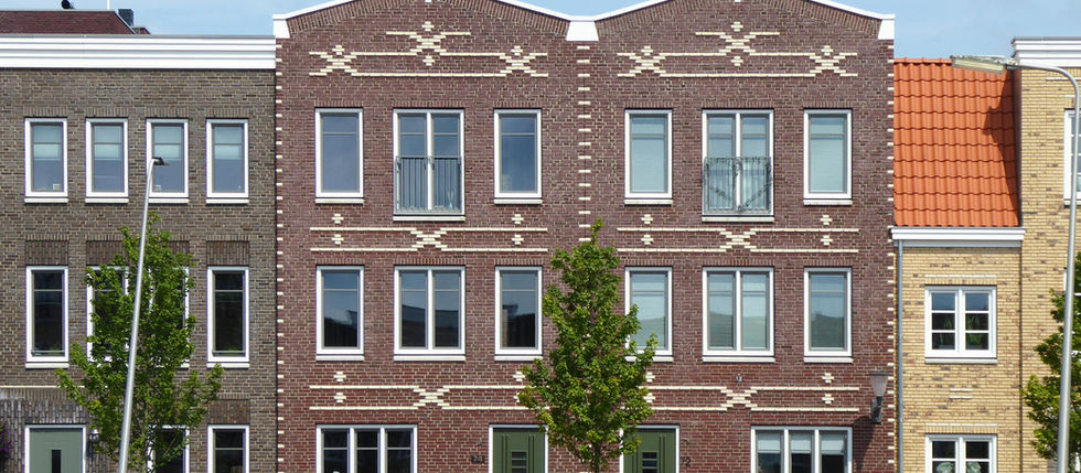 A row of houses with windows and a green lawn