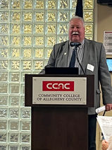 A man standing at a speaker's podium at CCAC.