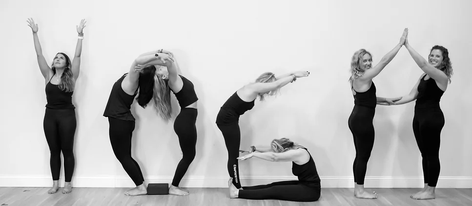 Yoga teachers spelling out the word YOGA with their bodies, in black and white. At The Practice Buffalo, a yoga studio.