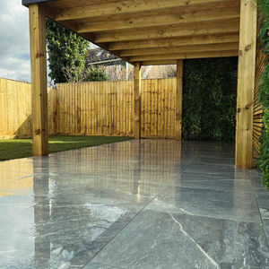 a patio with a wooden fence in the background and timber pergola