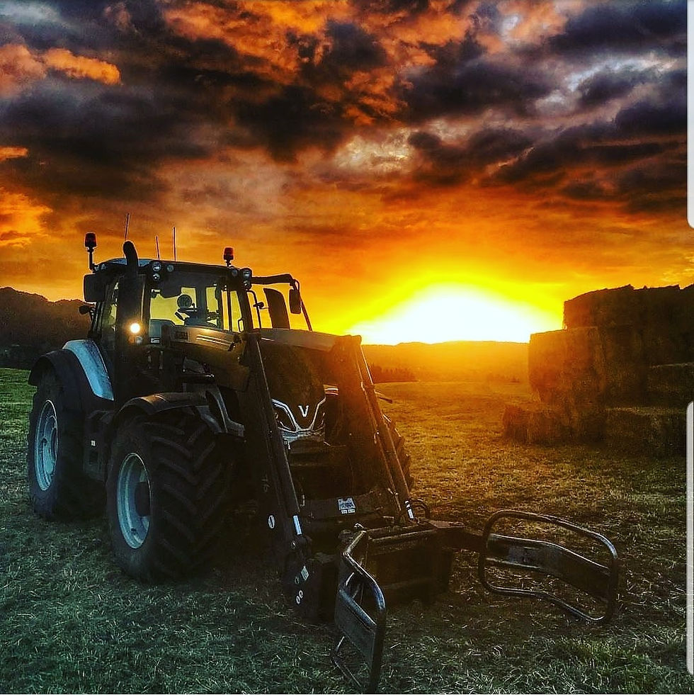 Valtra tractor in front of hay bales at sunset on Bay of Plenty farm