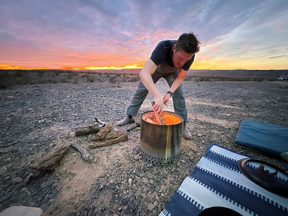 Building a campfire as the sun sets.