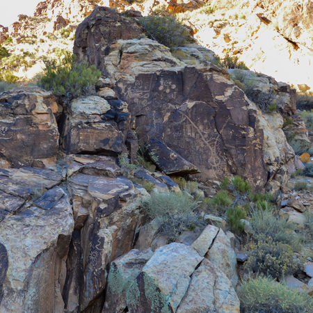 Large sandstone rock formations in Parowan Gap Utah with visible ancient carvings across surfaces