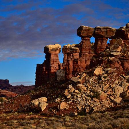 Four prominent sandstone rock formations standing together in the desert landscape of Canyonlands National Park