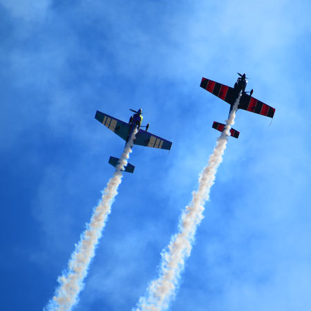 Vintage military aircraft surrounded by smoke during an aviation demonstration at an air show
