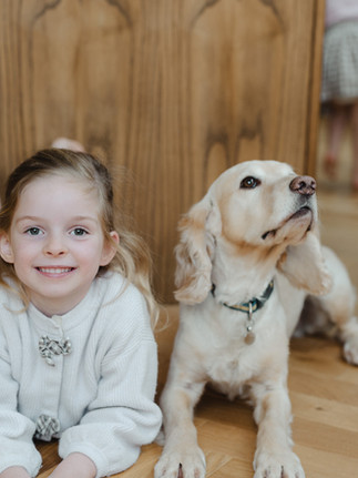 Natural, unposed portrait of a five year old girl smiling at the camera in her Peckham home.