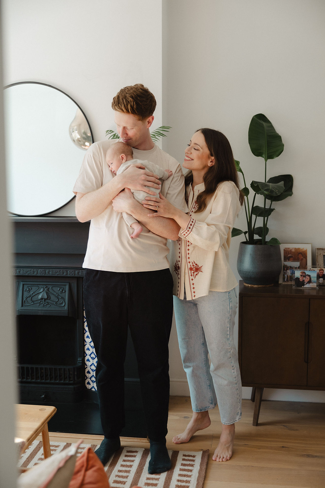 Mother and father holding premature newborn baby boy during East Dulwich home photo shoot