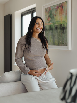 Artistic silhouette of a baby bump against a bright window during a London maternity shoot.
