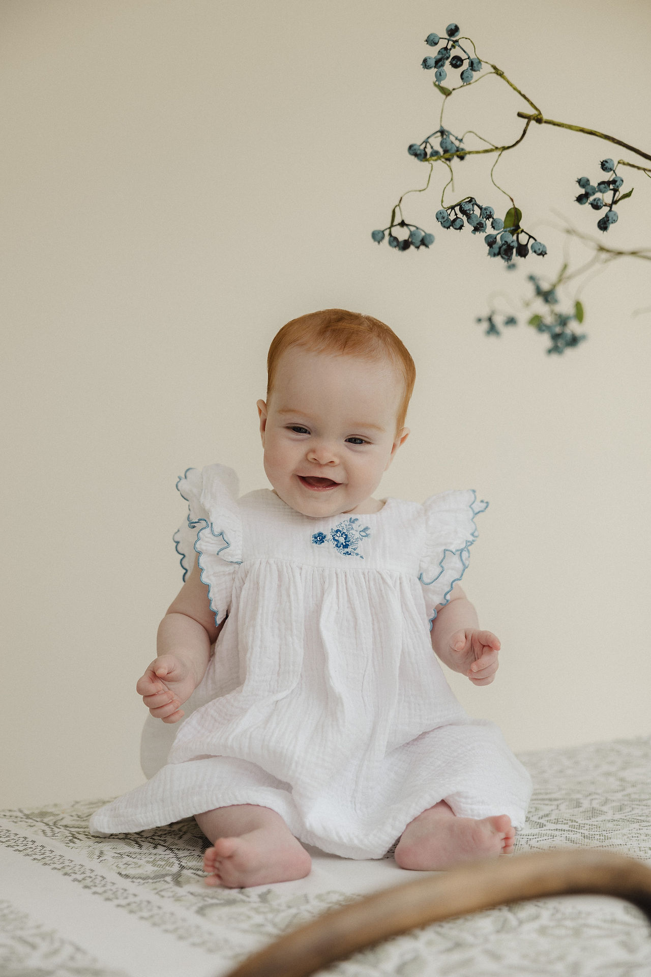 Baby girl sitting independently and smiling during an in-home photoshoot in South London.