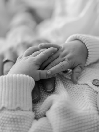 Black and white macro family photograph of a newborn's tiny fingers.
