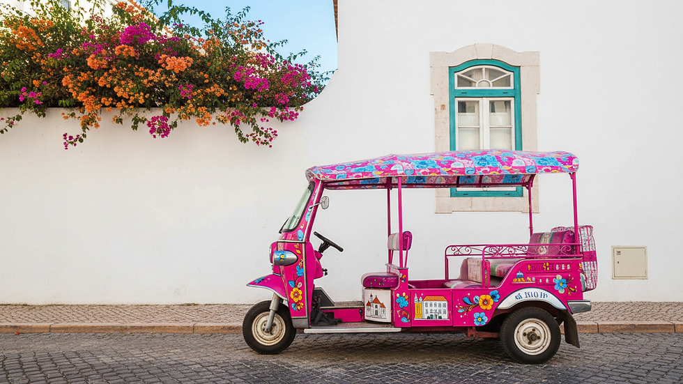 Eye-level view of a colorful tuk tuk parked near Lisbon’s historic Alfama district