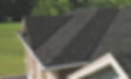 The image depicts a close-up view of a shingle roof with an open valley. The shingles on the roof are dark in color and have a textured, three-dimensional appearance. The open valley is a V-shaped channel that runs along the slope of the roof, separating two sections of the shingles. The valley is lined with metal flashing, which is visible through the gap in the shingles. The flashing is designed to guide water down the valley and into the gutters, preventing it from seeping under the shingles and causing damage to the roof's structure. The open valley is a popular design choice for shingle roofs as it allows for efficient water drainage and reduces the risk of leaks.