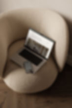 Laptop displaying the Madison Parker Interiors Services page with a phone resting on top showing the