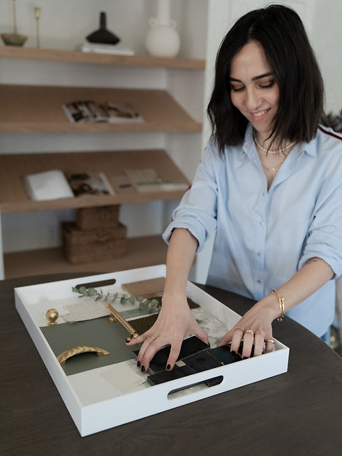 Burcu curating design materials including fabrics, finishes, and samples for the Design for a Day service, showcasing hands-on, personalized interior design work.