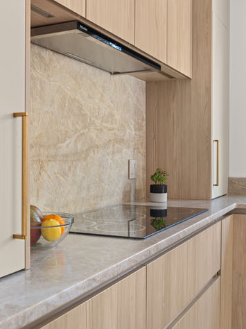 Electric stovetop on the counter in a neutral light-tone kitchen with white cabinetry, offering a sleek, modern, and functional cooking space.