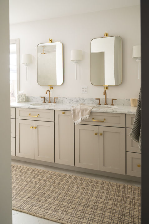 Primary bathroom with double vanity and checkered rug in a neutral, earth-toned luxury home in Rochester, Michigan