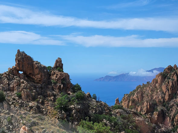 Overlook of mountains, ocean, and sky in Corsica, France.