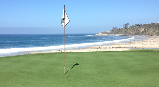 Golf course green near the Pacific Ocean.
