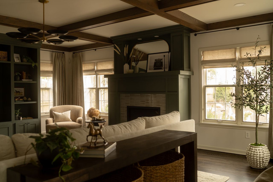 Full-service living room design featuring coffered wood-beam ceilings, modern lighting, a gas fireplace, custom media center, and curated décor.