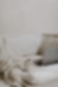 A cozy white couch with a blanket, coffee mug, and open laptop, creating a welcoming and relaxed setting that reflects the approachable experience of working with Cathleen Hall Creative.