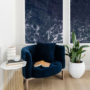 Cozy living room area designed with intention by an interior designer, featuring a seating area, potted plant, and table, symbolizing the importance of purposeful design on your website.