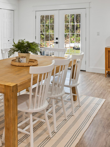 Santa Rosa Beach dining area in Santa Rosa Beach, FL with wooden table, white chairs, and coastal-inspired accessories, creating a luxurious beach-style interior.