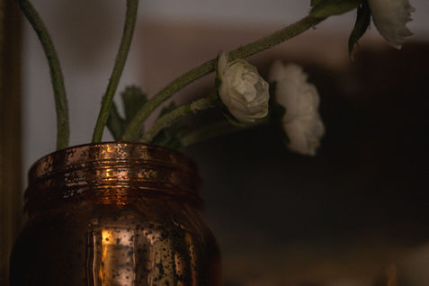 Close-up of bronze mason jar styled with flowers.