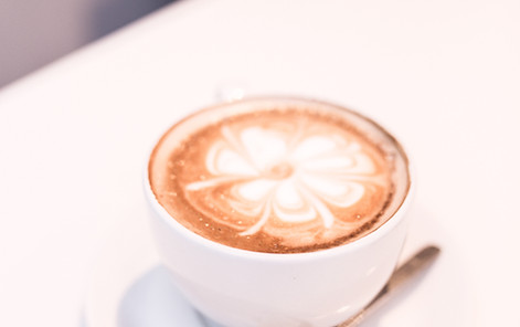 A hot latte with four leaf clover design at a small cafe in Paris.