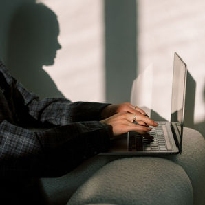 Close-up of a woman working on her laptop, adding a contact form to her Wix site step-by-step for better client connections.